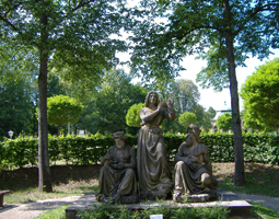 Eine Skulptur bestehend aus drei Personen aus Stein im Park.