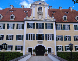Schloss mit gelber Fassade im Hintergrund blauer Himmel